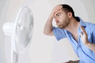Man very hot in front of fan